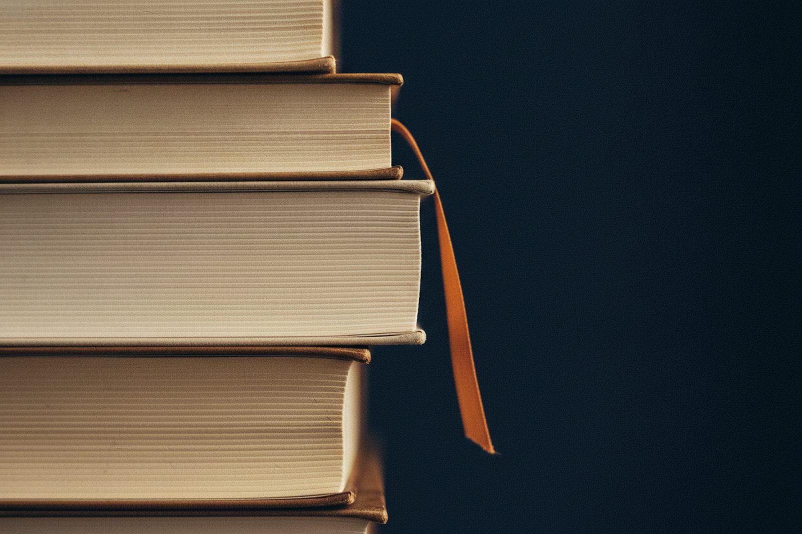Ledger books, edge on, with an amber ribbon
